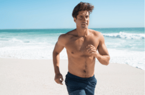 Fit man jogging on the beach.